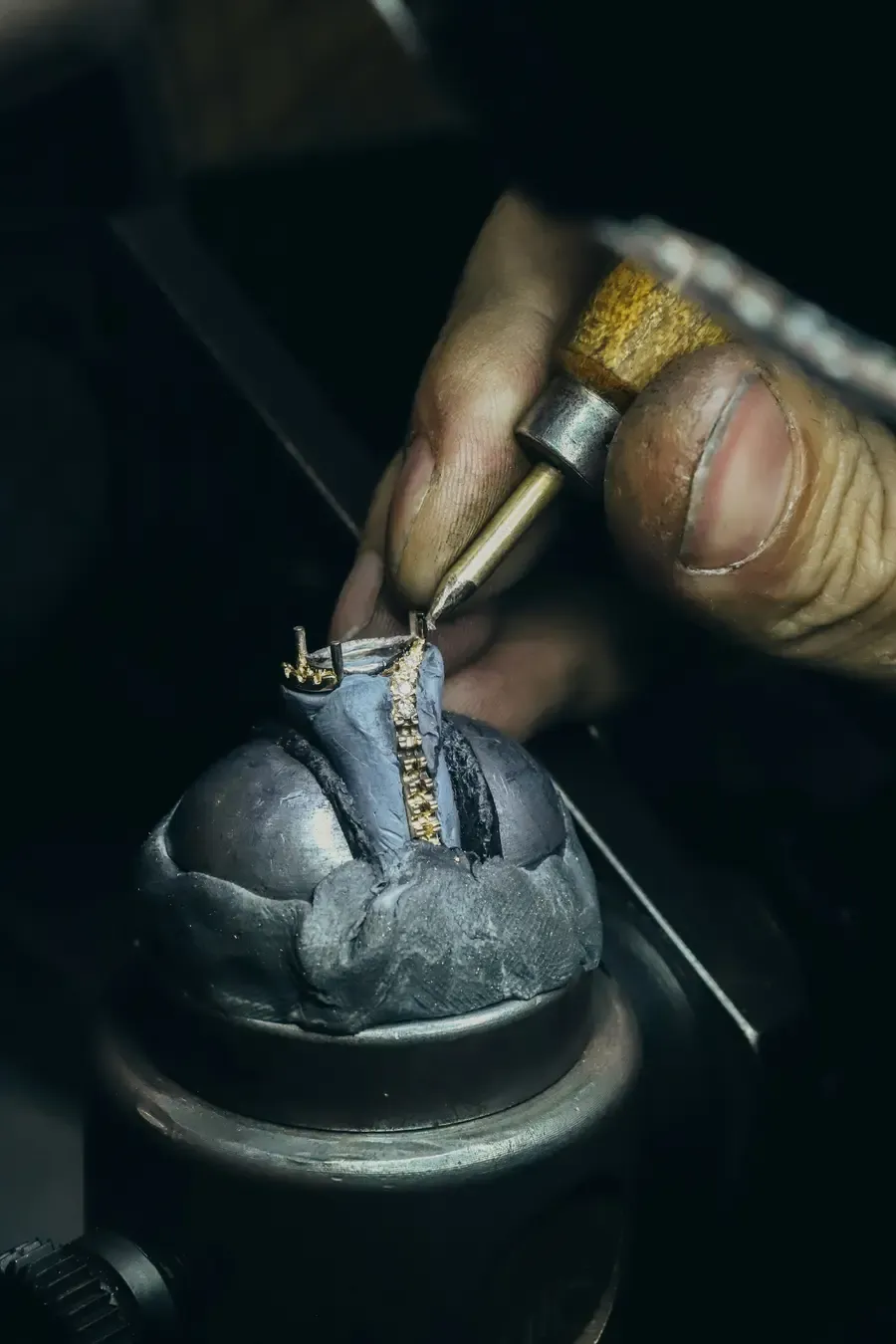 Bijoutier sertissant à l'échoppe une bague maintenue dans la boule de sertissage
