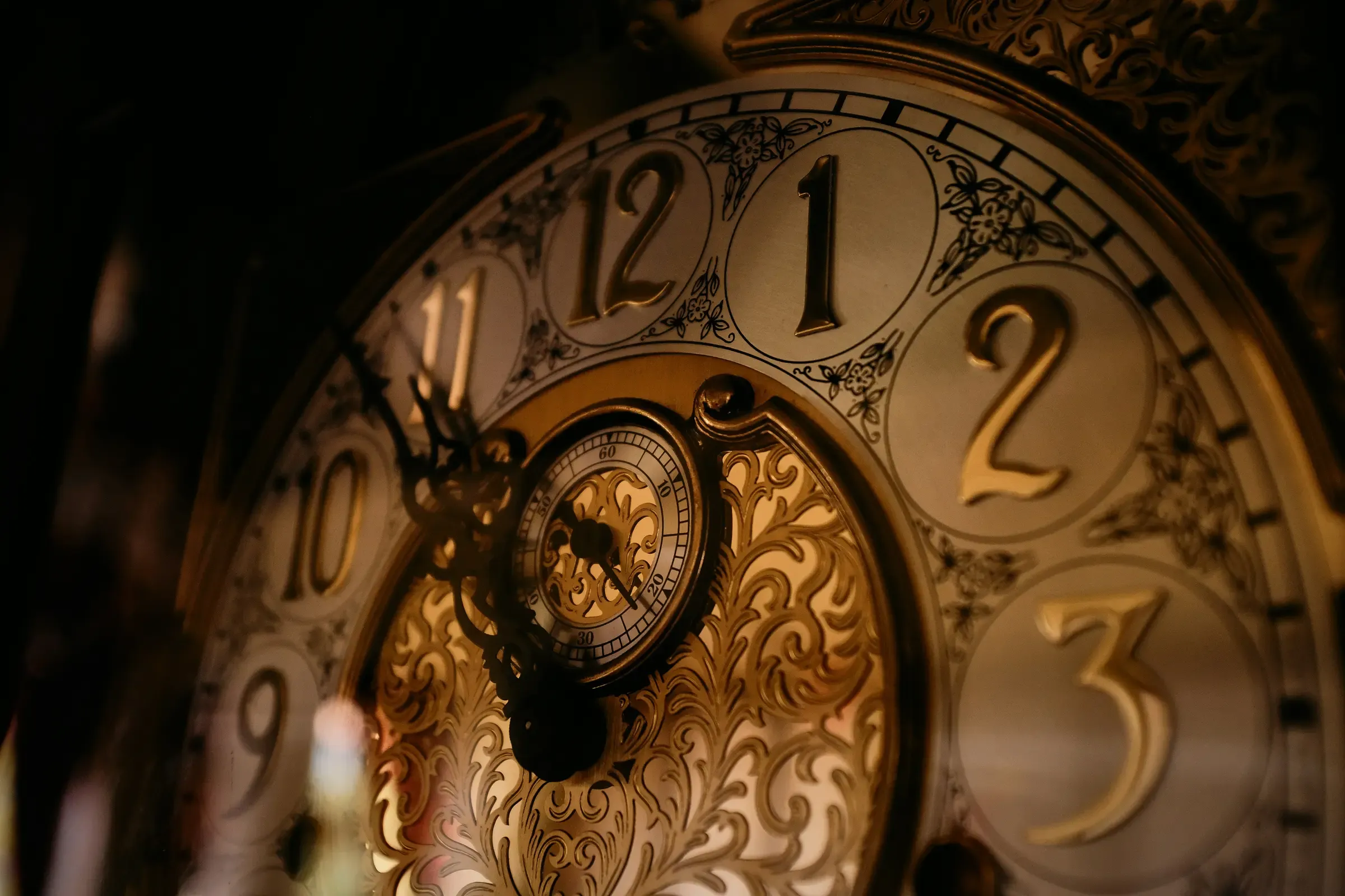 Cadran ouvragé d'une horloge de parquet, chiffres dorés et cadran des secondes