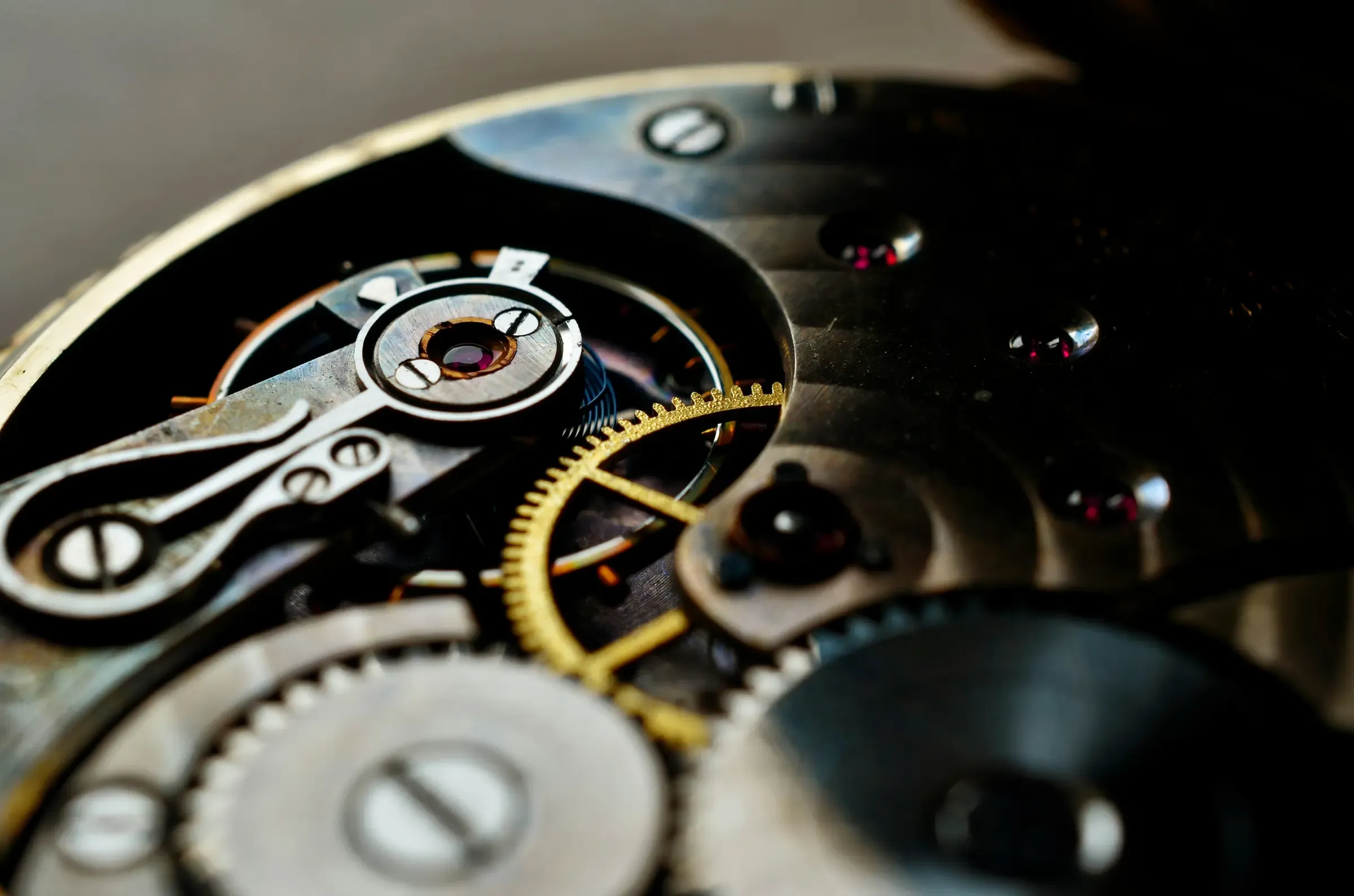 Gros plan sur le mouvement mécanique d'une montre : rouages, rubis et ponts