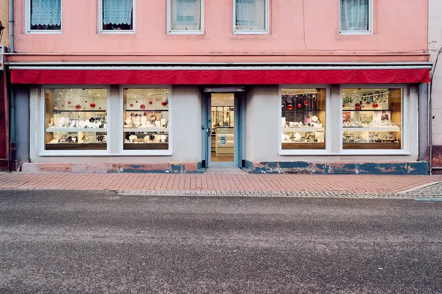 Façade de la boutique Fassler à Schirmeck, vitrines illuminées sous un store rouge